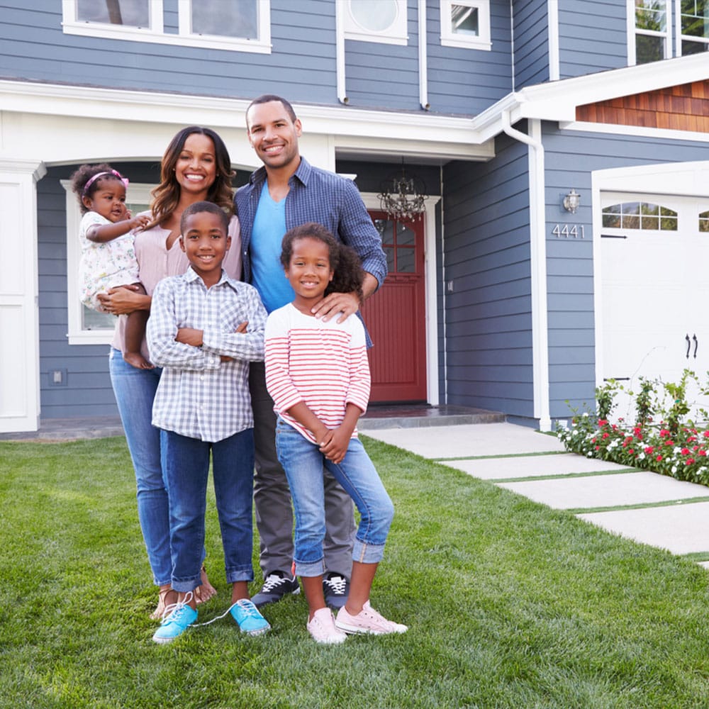 Tamiko Nash, Levon Rector posing in front of a house
