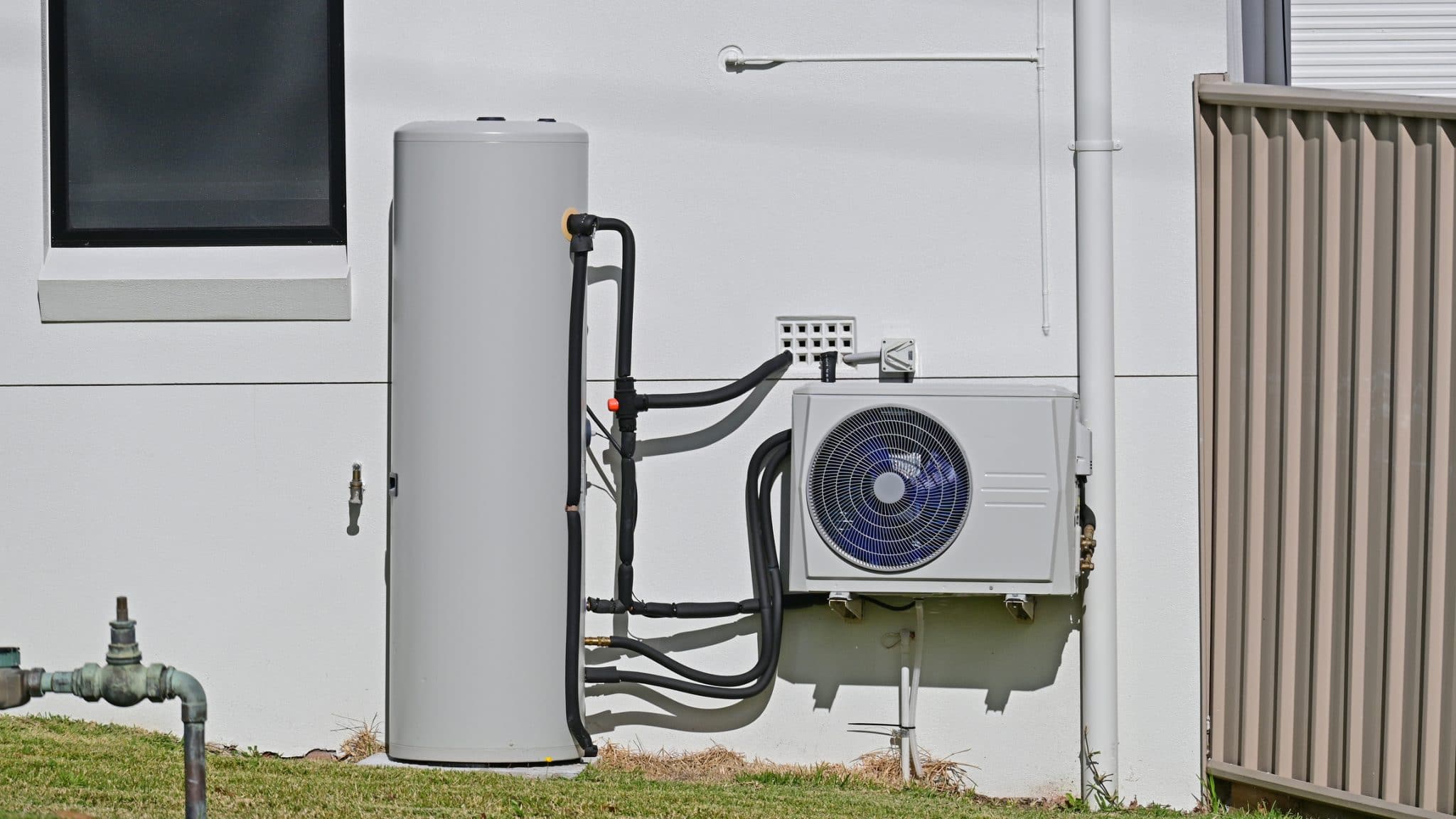 A brand new heat pump water heater installed outside of a home.