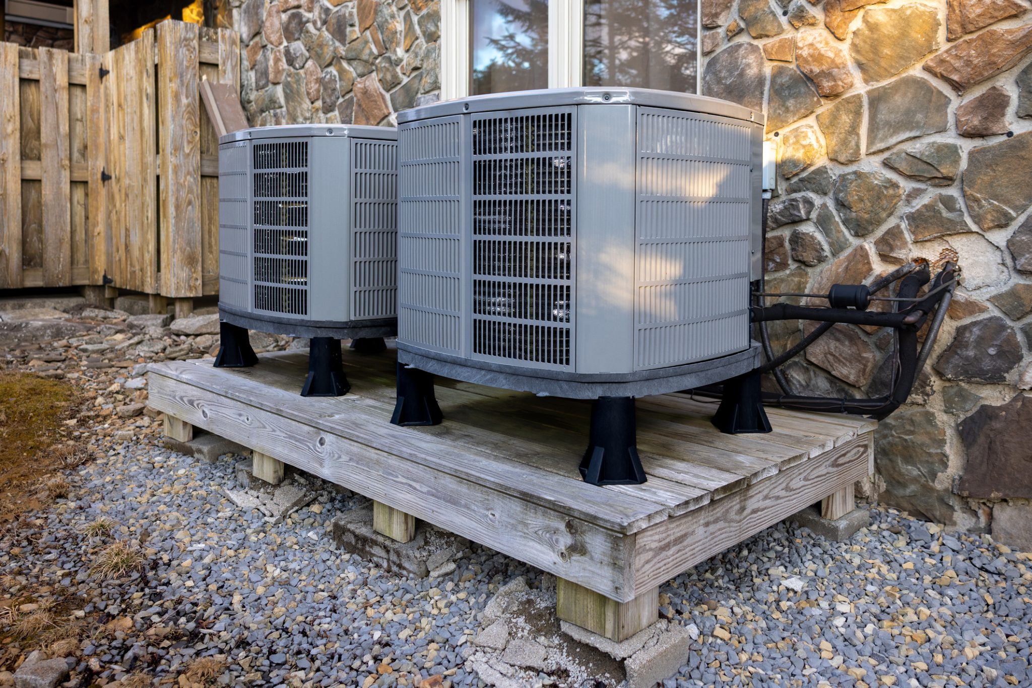 Two heat pumps set up outside a home as part of a dual-fuel heating system.