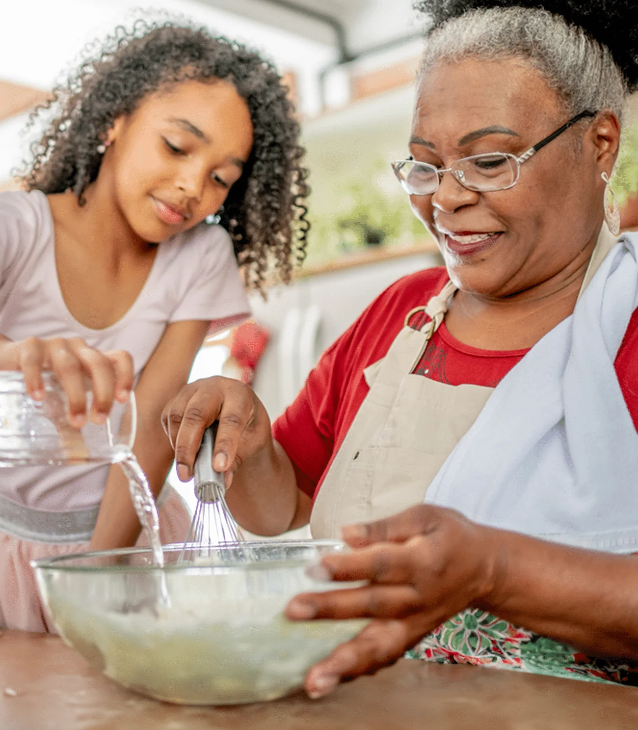 a group of people preparing food in a bowl